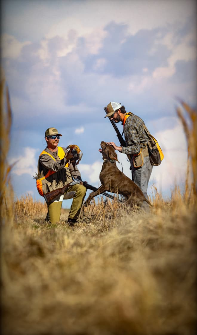 Hunters with gun dog after successful hunt